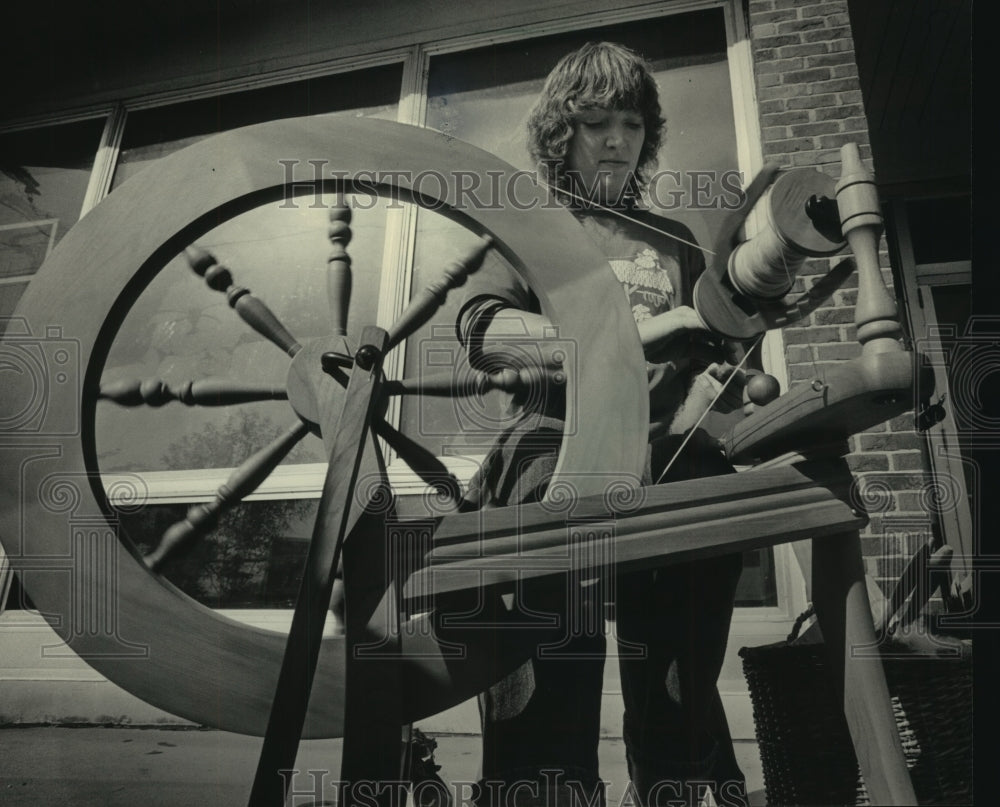 1984 Press Photo Dorothy Spransy spins wool on spinning wheel at library - Historic Images