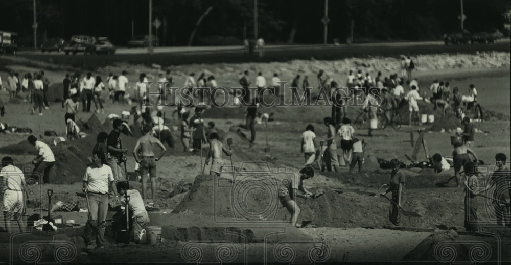 1988 Press Photo Hundreds of people spend the day reshaping the beach - Historic Images