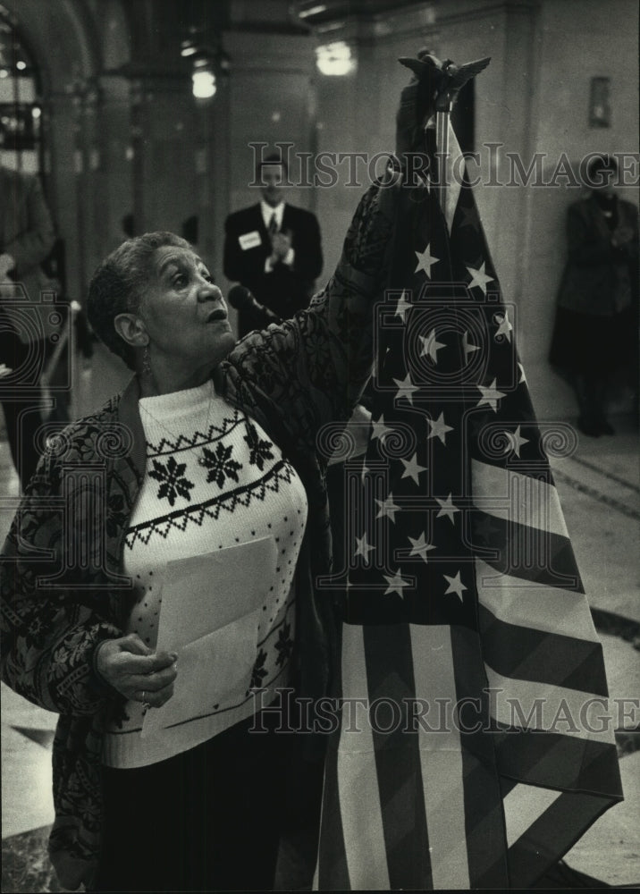 1992 Press Photo Augusta Tranitt hangs a ribbon on American flag in Milwaukee - Historic Images