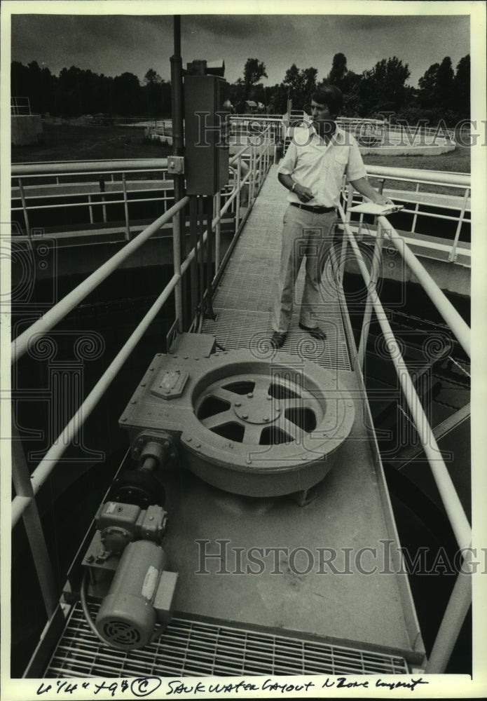 1981 Press Photo Skatrud standing on bridge over treatment tanks, Wisconsin. - Historic Images