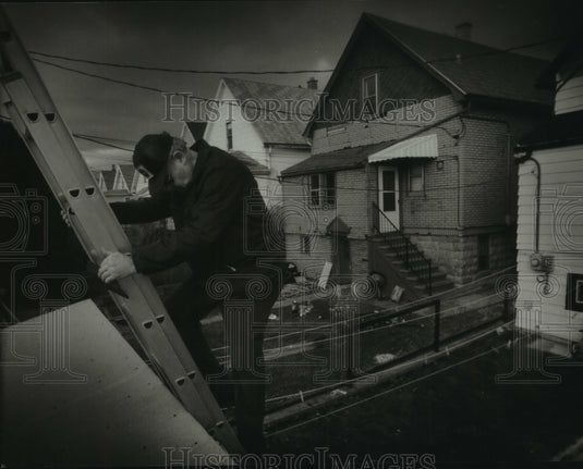 1993 Press Photo Building Inspector Lloyd Schneider climbs down from a roof - Historic Images