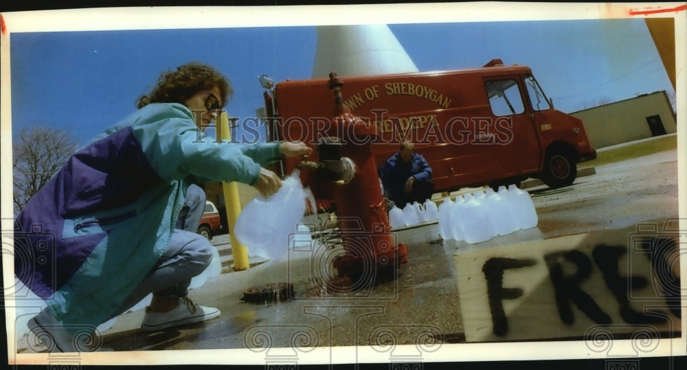 1993 Press Photo Mary Fredericks fills container with water in Sheboygan, WI - Historic Images