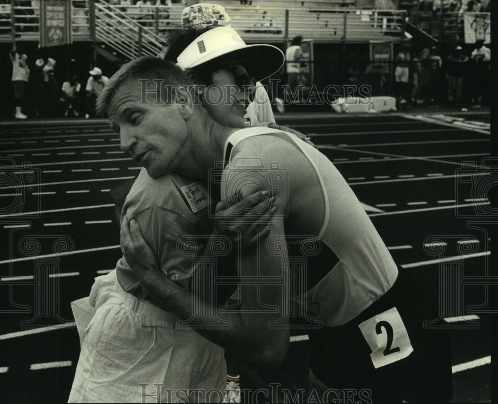 1991 Dale Kunkel, competitor in Special Olympics, hugs volunteer.-Historic Images
