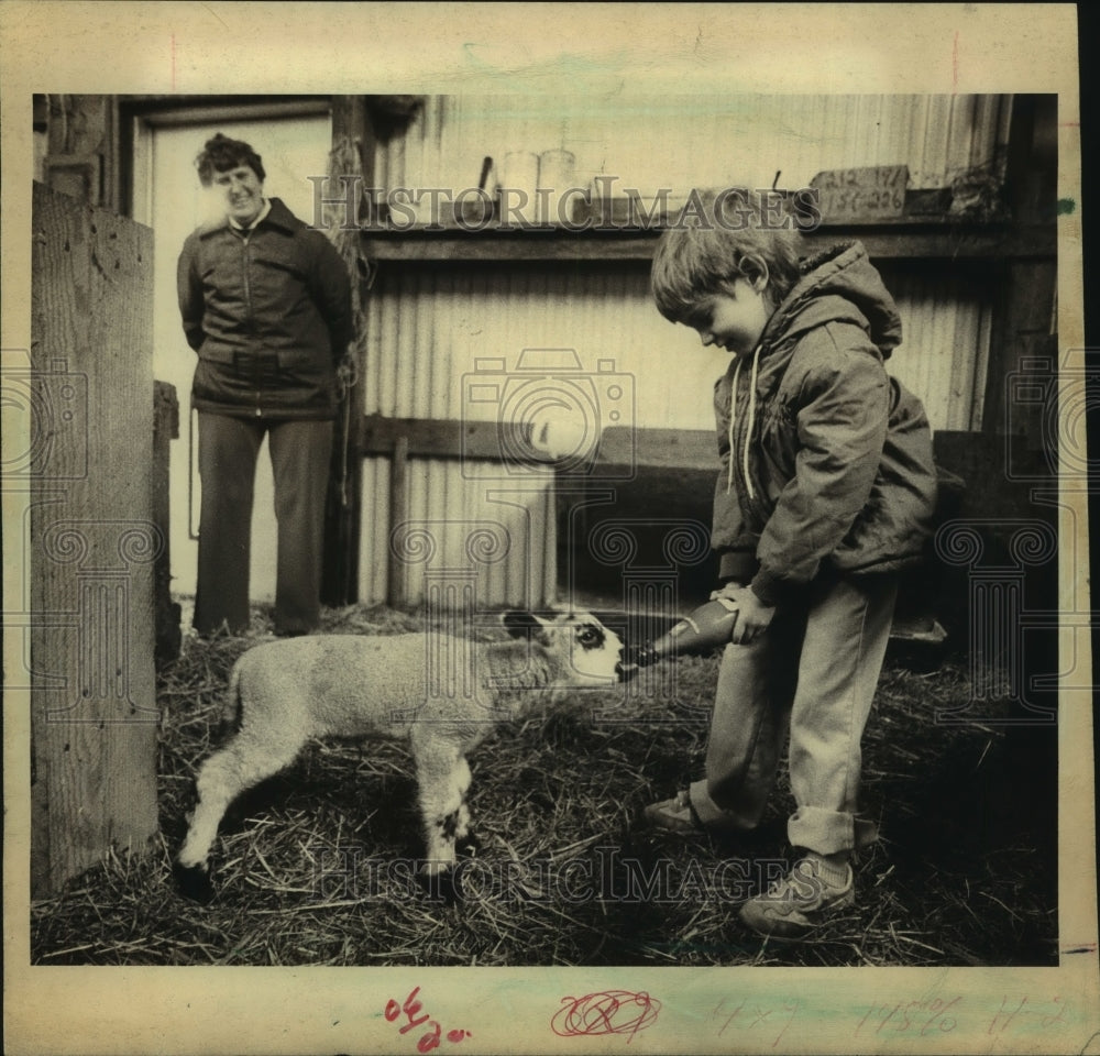 1985 Press Photo Violet Capelle watching her granddaughter feed lamb, Wisconsin. - Historic Images