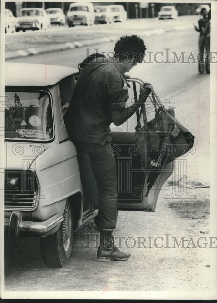1973 Press Photo Israeli soldier, pack with sub machine gun, getting into car - Historic Images
