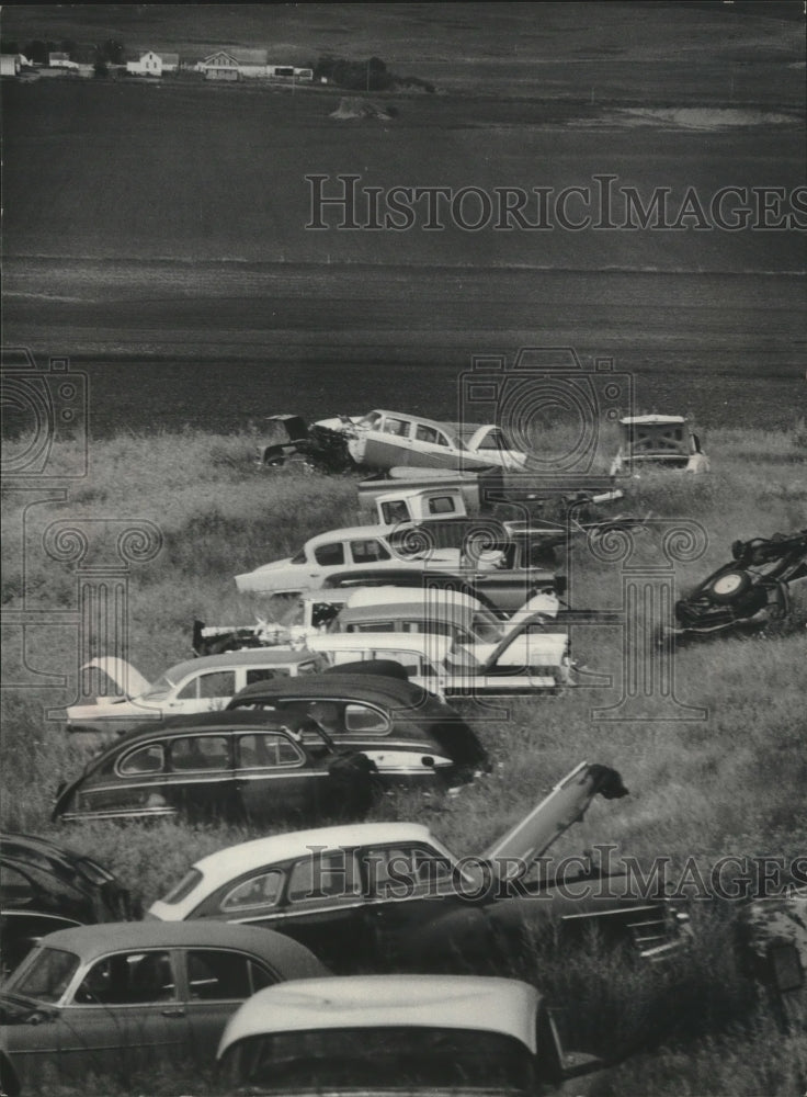 1976 Press Photo Beyond these junked cars is the site of the proposed plant - Historic Images