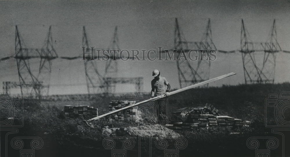 1976 Press Photo A power construction worker labors on building site - Historic Images