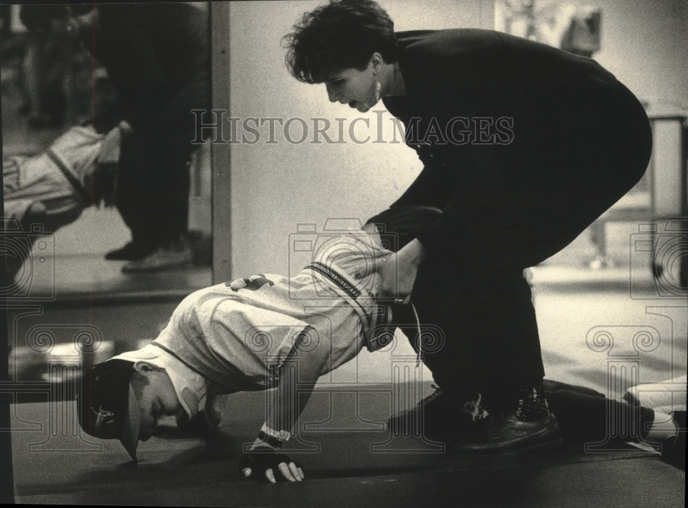 1992 Aaron Powless does push-ups as therapist helps him through task-Historic Images