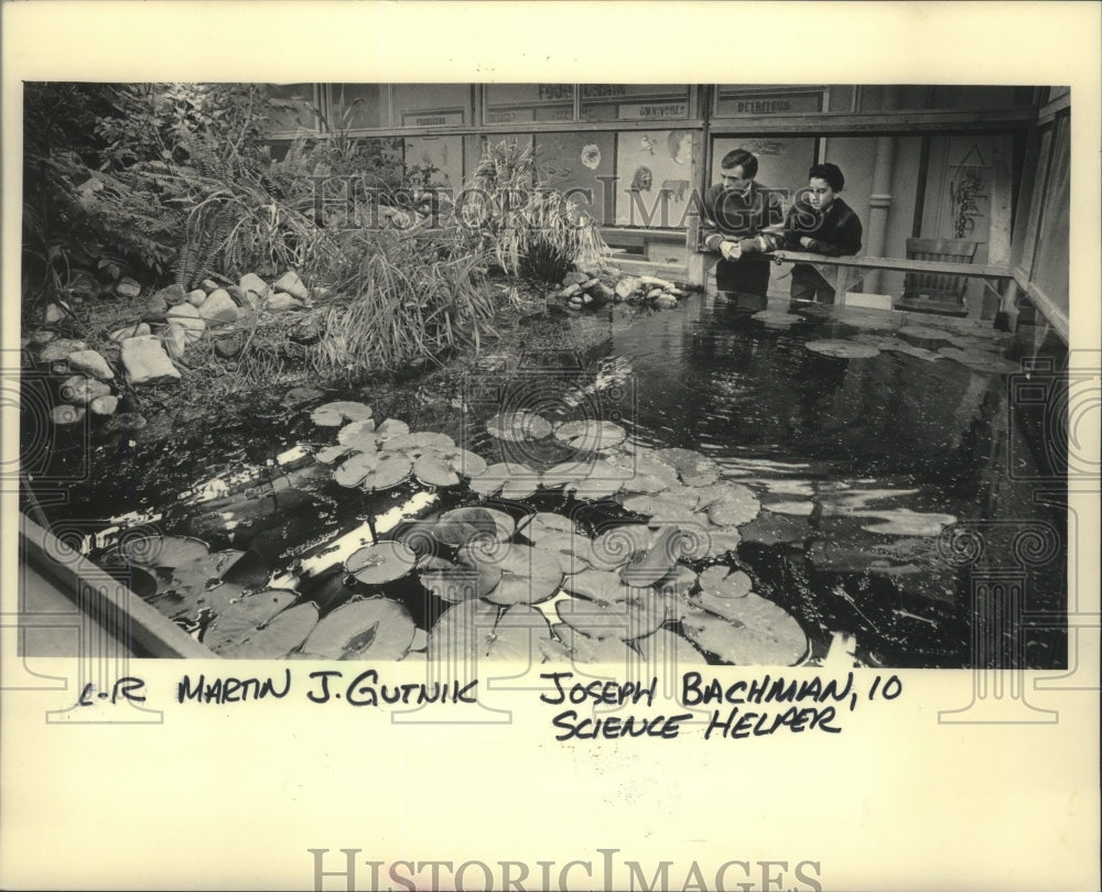 1985 Press Photo Marty Gutnik, Joseph Bachman inspect indoor pond-Atwater Elem - Historic Images