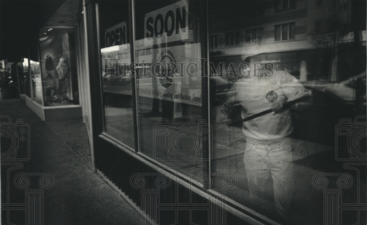 1993 Press Photo Walter Gottschalk puts final touches on Travel agent's store. - Historic Images