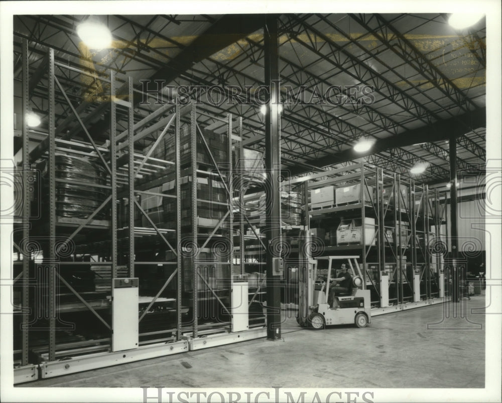 1992 Employee of Spacesaver Corporation demonstrates rack system - Historic Images