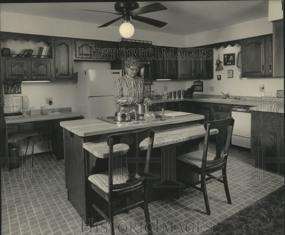 1984 Press Photo Helen Schmitz cooks in the kitchen of her solar home - Historic Images