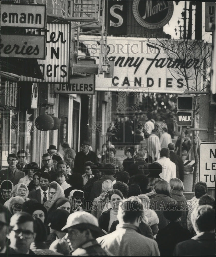 Press Photo Crowd moving down the street near businesses - mjb97373 - Historic Images