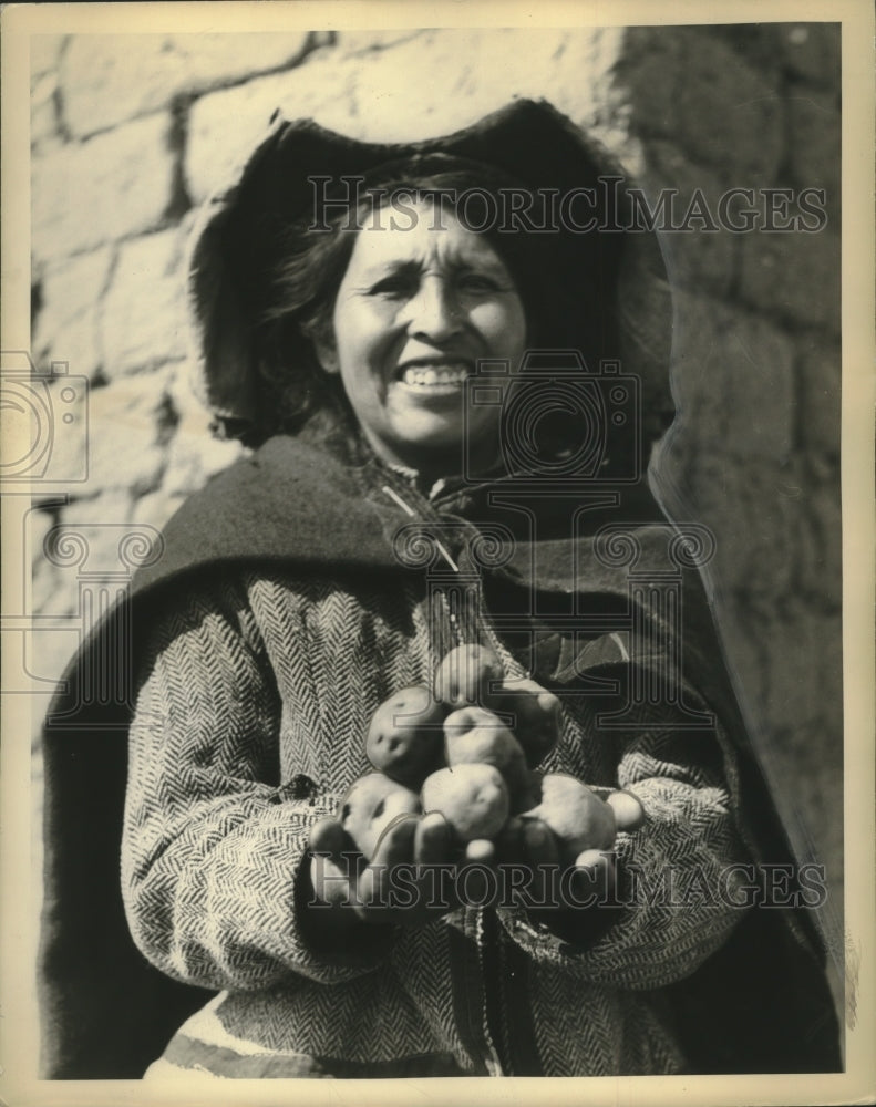 1937 A woman of the Andes holding potatoes. - Historic Images