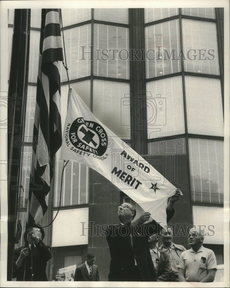 1950 Press Photo Fred Salmon raises pennant at A.O. Smith Corp. flagpole. - Historic Images