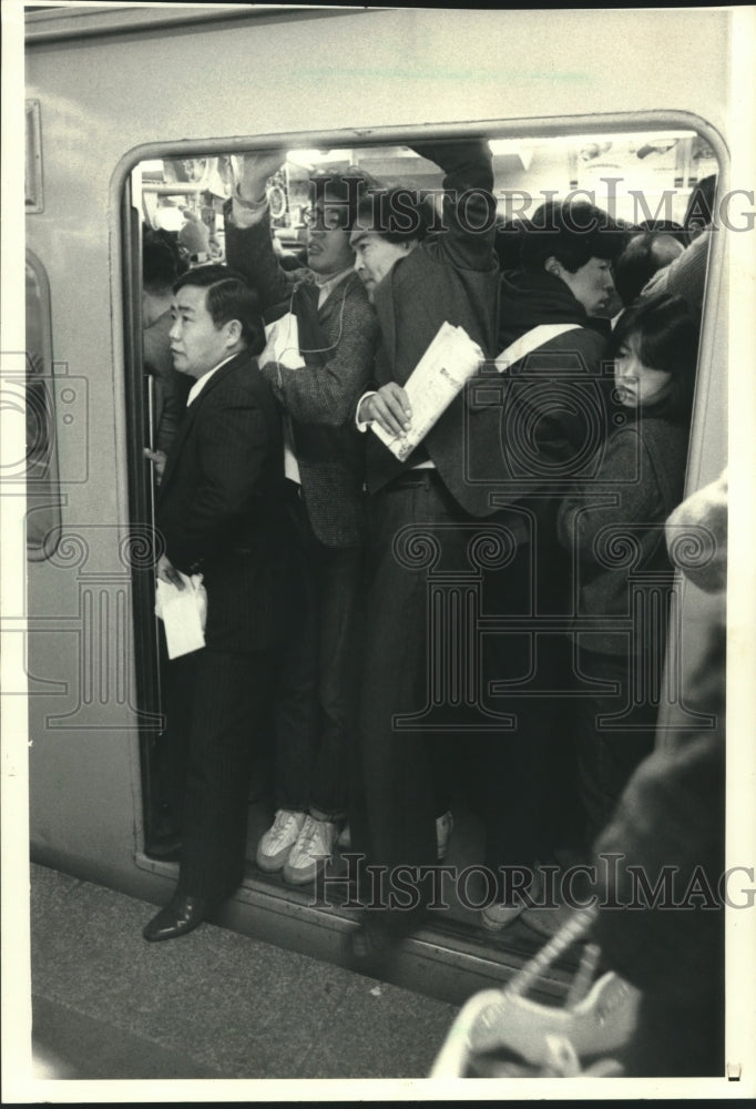 1986 Commuters squeeze into train at Tokyo&#39;s Shinjuku station - Historic Images