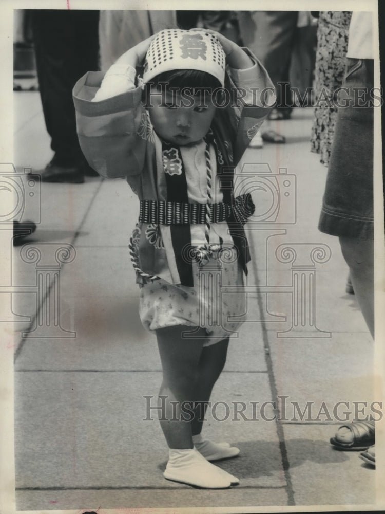 1983 Press Photo Young Japanese girl, hands on head, during summer festival - Historic Images
