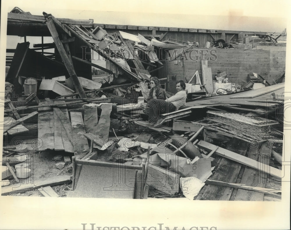 1977 Gerald Grunwaldt and wife sitting on ruins of barn, Wisconsin. - Historic Images