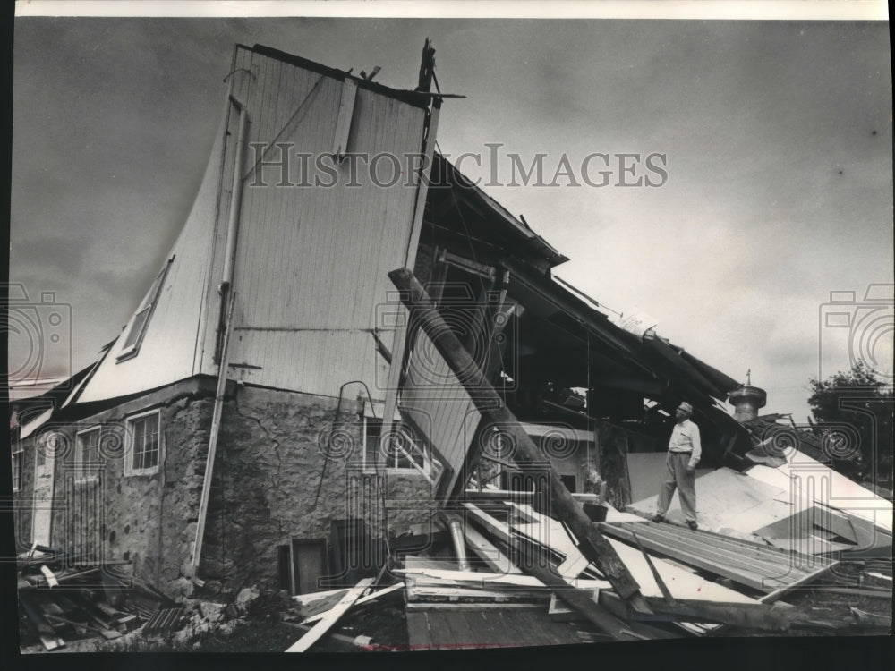 1963 Press Photo Clarence Knnap looking over storm damage on barn, Wisconsin. - Historic Images