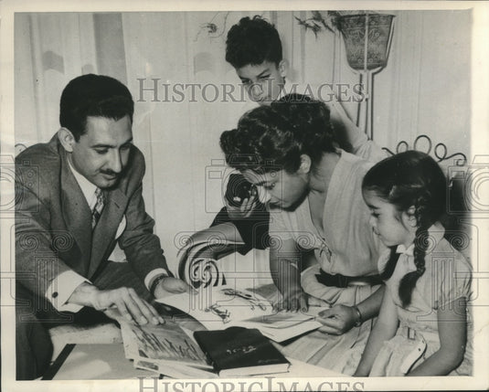 1956 Press Photo Royalty of Iran looking over translated American books. - Historic Images