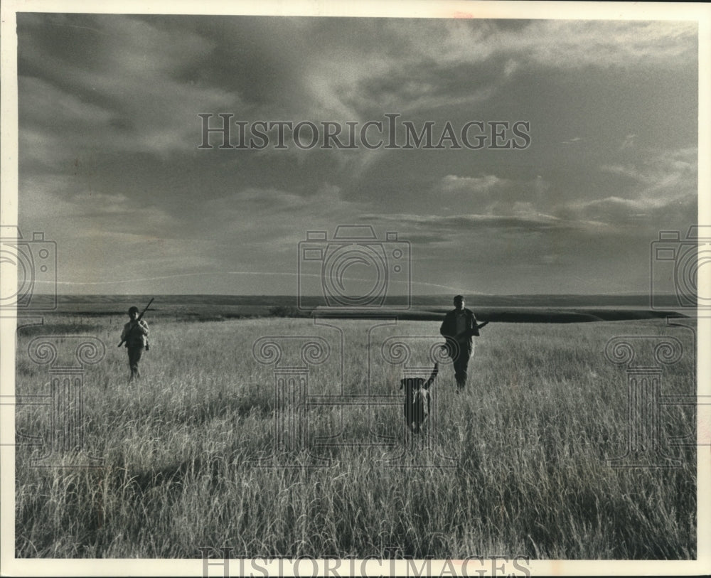 1991 Press Photo Game hunters walk the fields with dogs in search of game birds. - Historic Images