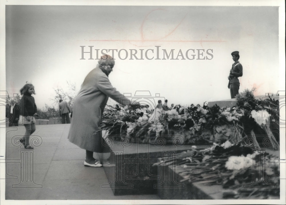 1976 Press Photo Mother places flowers on a memorial to W.W.II dead at Kiev. - Historic Images