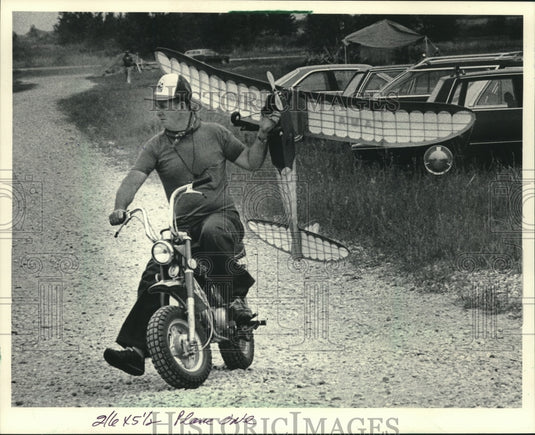 1984 Harold Munge retrieves his model plane after a flight. - Historic Images