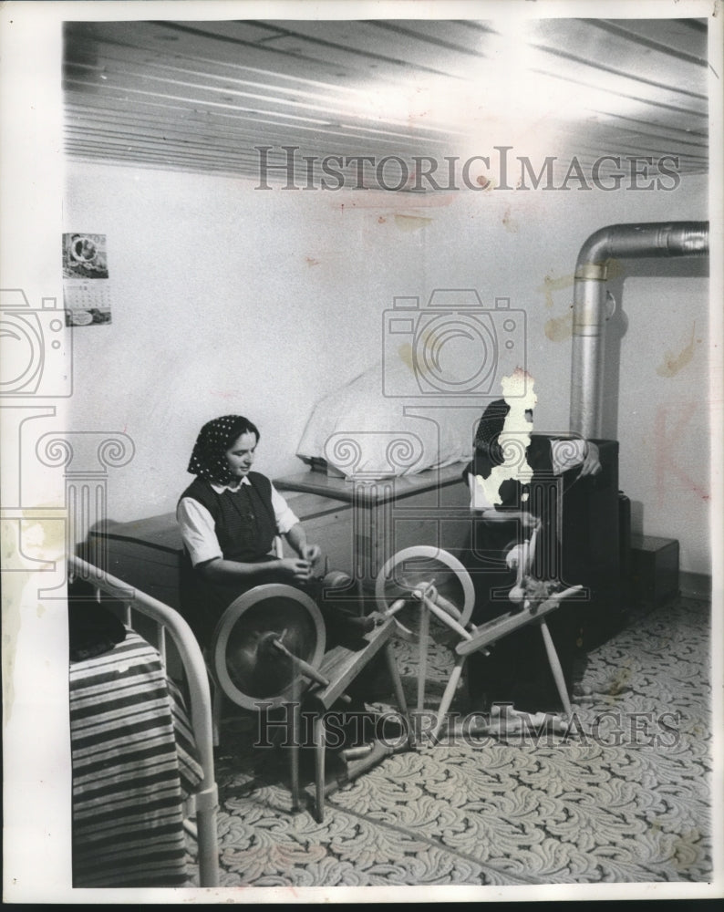 1956 Press Photo Two young women spin yarn from which they will weave clothes . - Historic Images