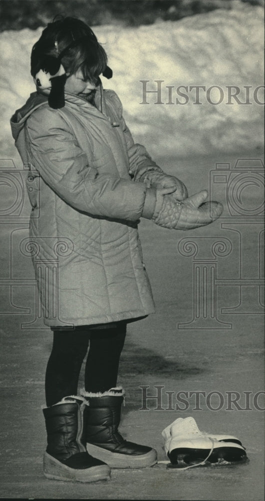 1986, Kathee Brautigan, puts mittens on after skating in Milwaukee. - Historic Images