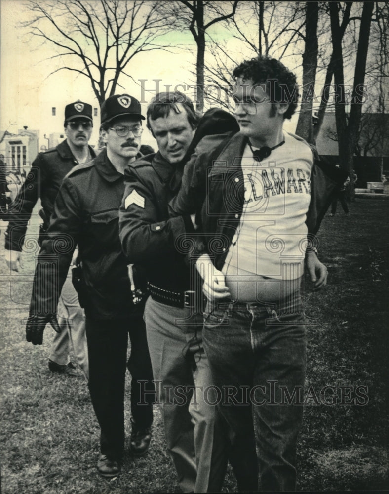 1986, Police escort a student from demonstration Madison Wisconsin - Historic Images