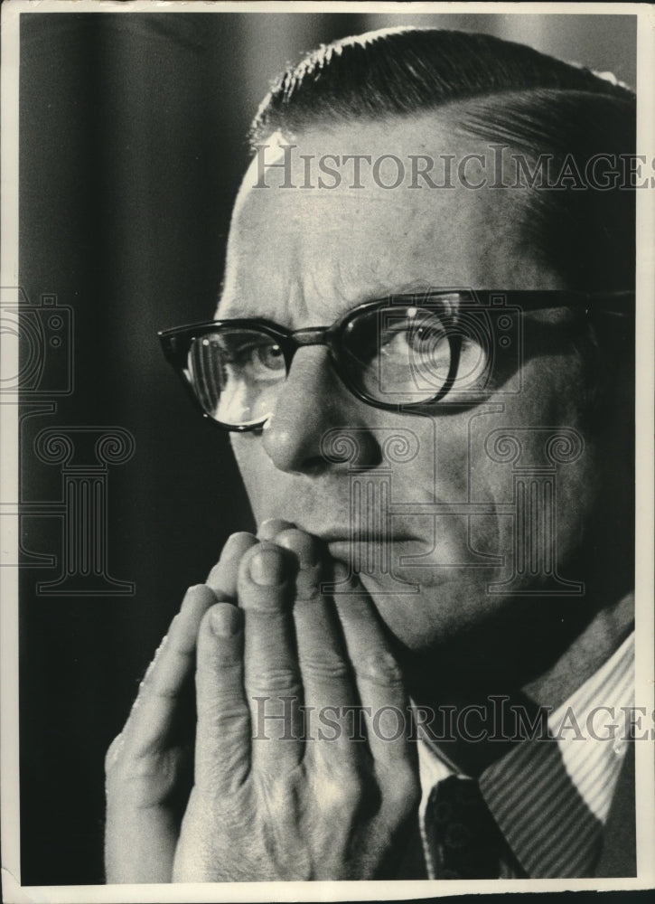 1974, William E. Simon listens intently, hands joined, in Washington. - Historic Images