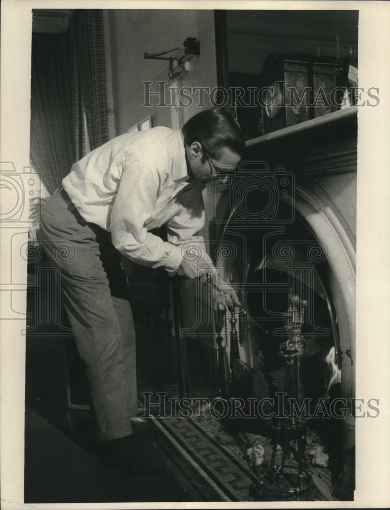 1974 Press Photo William Simon stokes a fire in Washington office on Saturday. - Historic Images