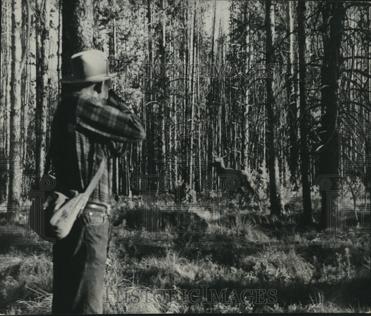 1950, Elk Hunting-Hunter takes aim at Elk, as it prepares to flee - Historic Images