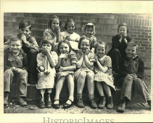 1983 Press Photo Children giggle, pose for class portrait outside their school - Historic Images