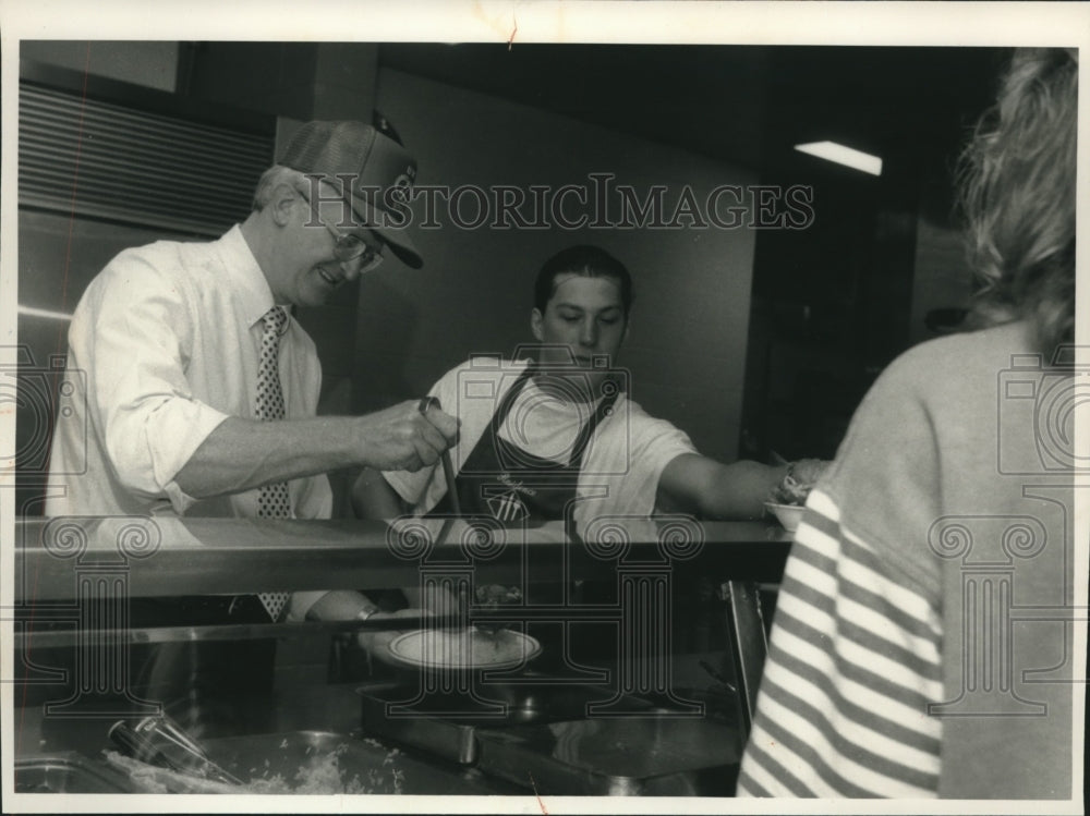 1989 Press Photo Chancellor Charles Sorensen serves food at UW-Stout - mjc01275 - Historic Images