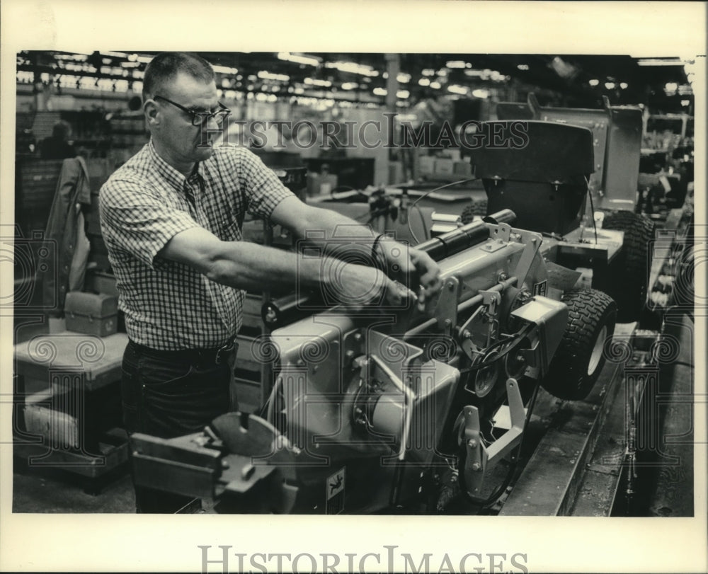 1984 Press Photo Employee tightening a bolt, Simplicity Manufacturing, Wisconsin - Historic Images