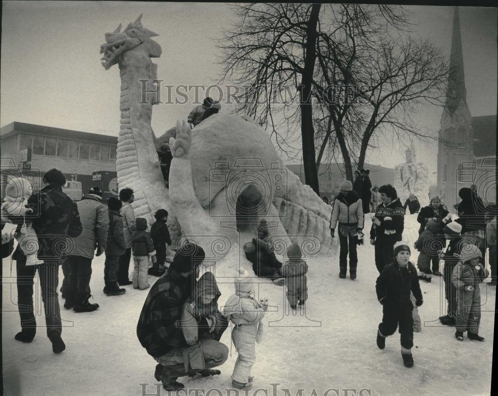 Press Photo Children play on giant snow sculpture in Cutler Park in Waukesha. - Historic Images