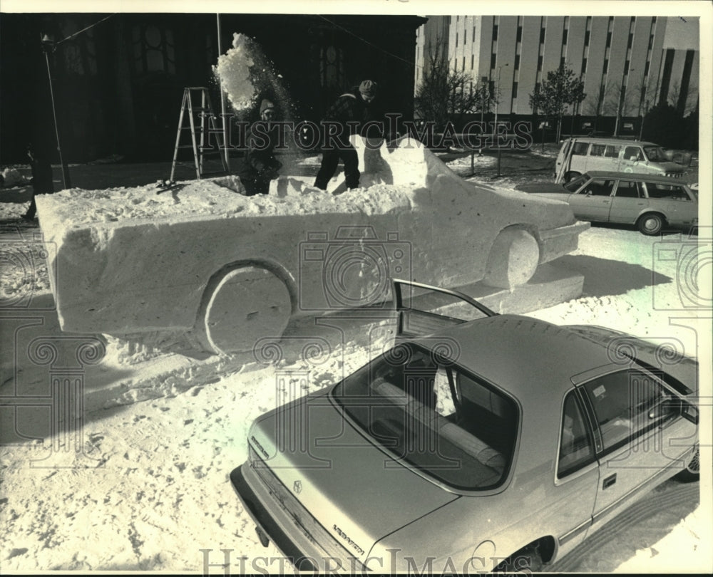 1987 Press Photo Michael J. Sponhoitz and Tom Queoff carve snow automobile. - Historic Images