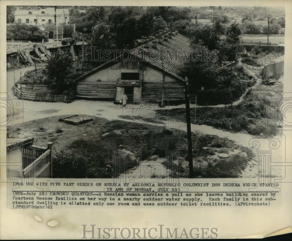 1962 Press Photo Russian Woman Carries Pail As She Leaves Building in Moscow - Historic Images