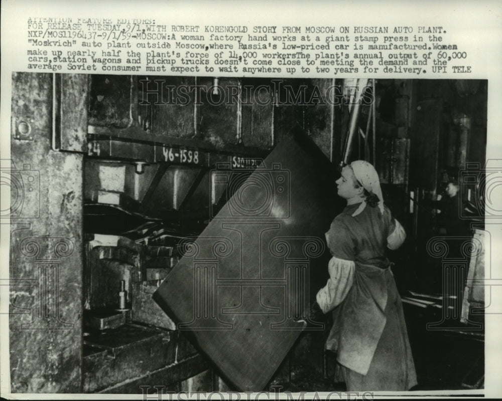 1959 Press Photo Woman works giant stamp press in auto plant Moscow, Russia - Historic Images