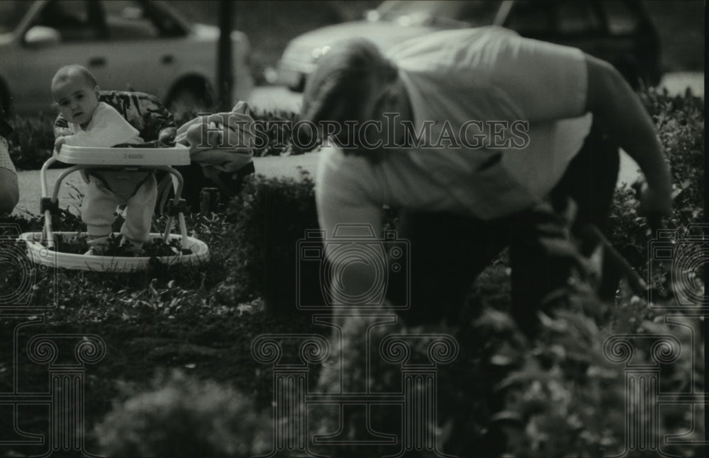 1994, Volunteers transform Milwaukee street planting flowers & shrubs - Historic Images