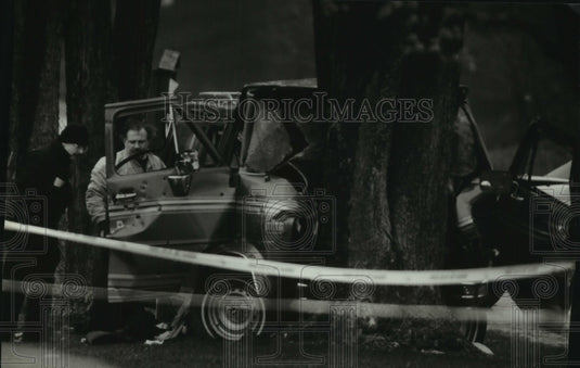 1994 Men examine James Oswald truck crashed into a tree - Historic Images