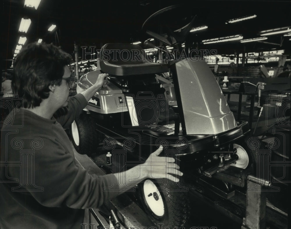 1992, Gene Swatek inspects a Simplicity Coronet riding lawn mower - Historic Images