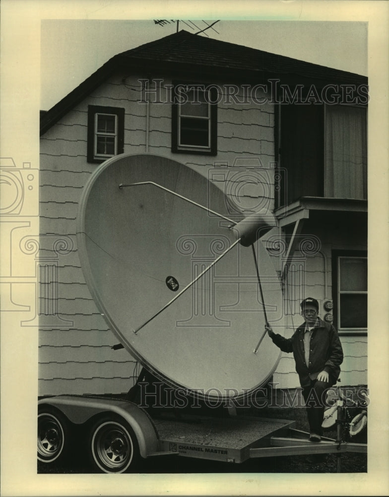 1994, John Richardson standing with satellite dish in his yard - Historic Images