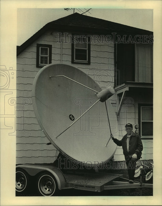1994, John Richardson standing with satellite dish in his yard - Historic Images