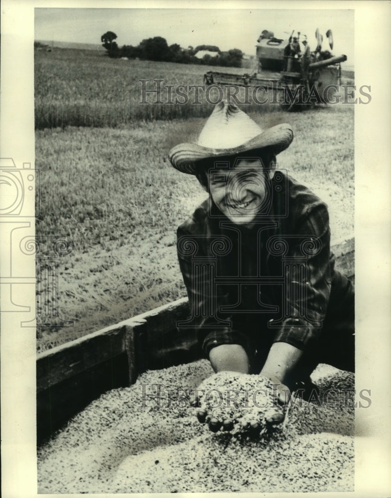 1975 Farm Machine Operator Holds Grain in Hands in Ukraine - Historic Images