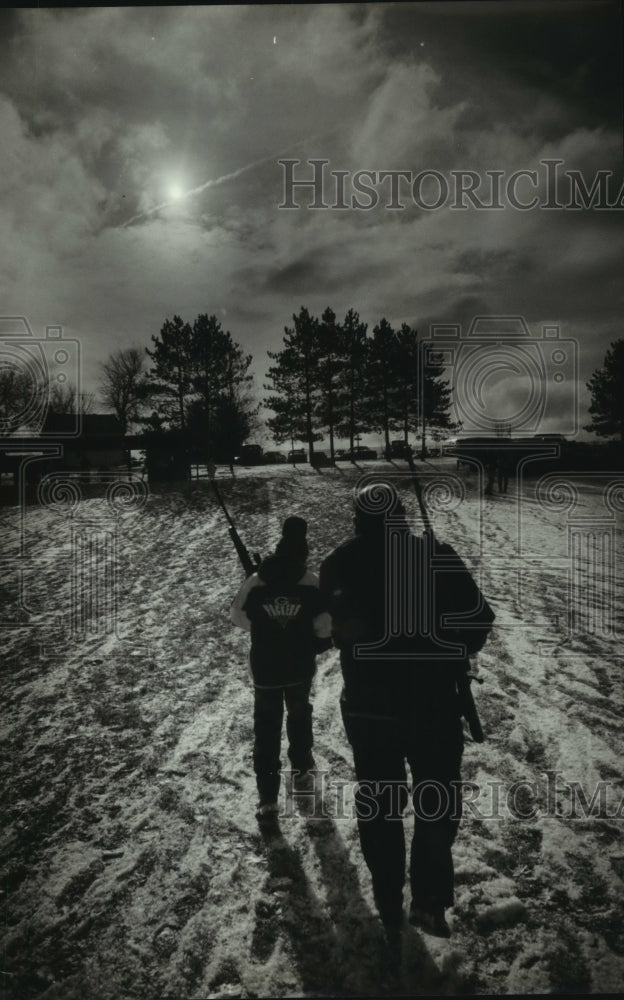 1993 Pair of hunters head home from hunter's clinic in Hubertus - Historic Images