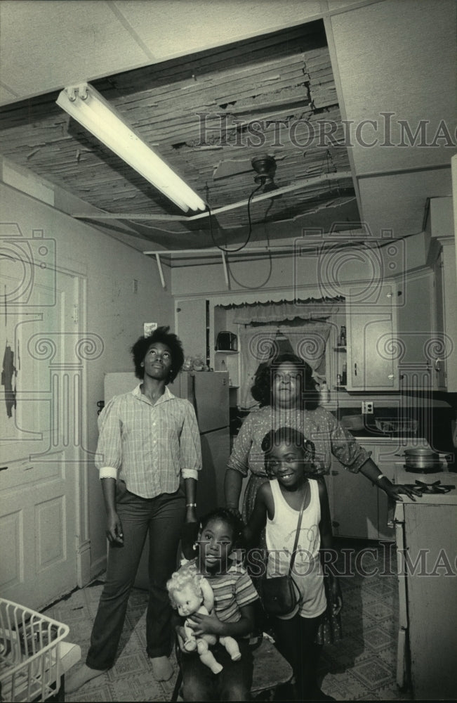 1984, Hernandez family standing in deteriorating kitchen, Milwaukee - Historic Images