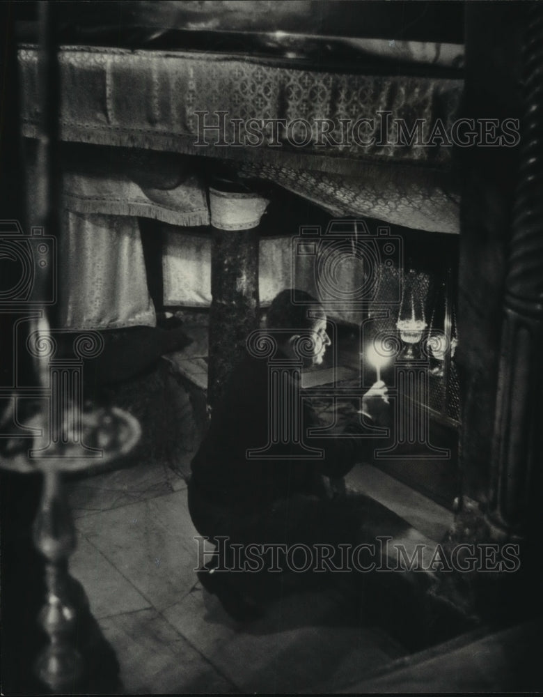 Press Photo Man kneels with lit candle appears in prayer - mjc02766 - Historic Images