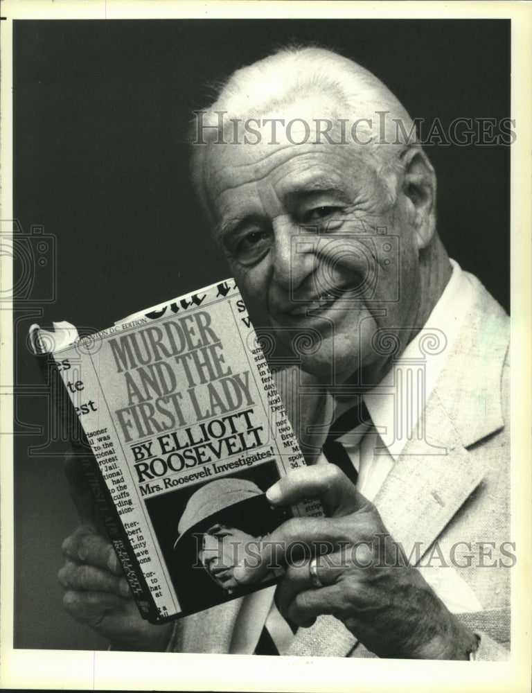 1984 New York-Elliott Roosevelt, shows press his new mystery book - Historic Images